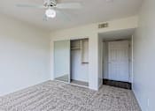 Thumbnail 10 of 21 - A room with a ceiling fan and carpeted floor.