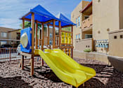 Thumbnail 19 of 21 - A playground with a yellow slide and a blue canopy.