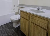 Thumbnail 5 of 15 - A bathroom with a toilet, sink, and mirror.