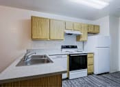 Thumbnail 1 of 15 - A kitchen with a white refrigerator, stove, and oven.