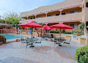 Thumbnail 11 of 15 - A patio with tables and chairs and umbrellas.