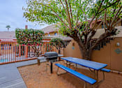 Thumbnail 15 of 15 - A blue picnic table is in front of a tree and a building.