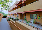 Thumbnail 10 of 15 - A building with a red roof and a balcony with a chair and table.