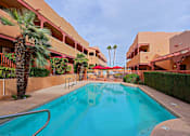 Thumbnail 12 of 15 - A swimming pool in a courtyard surrounded by buildings.