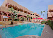 Thumbnail 13 of 15 - A large swimming pool in front of a building with a palm tree.