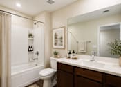 Thumbnail 16 of 29 - A bathroom with a white toilet, a white sink, and a white bathtub.