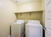 Thumbnail 13 of 29 - Two white front loading washing machines in a small laundry room.