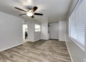 Thumbnail 5 of 9 - an empty living room with a ceiling fan and a window