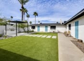 Thumbnail 3 of 9 - a white house with a yard and a blue door