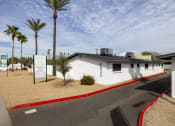 Thumbnail 1 of 9 - a white building with palm trees and a road in front of it