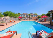 Thumbnail 27 of 29 - A large swimming pool with lounge chairs and umbrellas.
