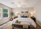 Thumbnail 14 of 29 - A bedroom with a large bed and a ceiling fan.