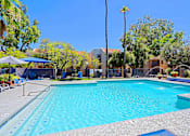 Thumbnail 32 of 36 - A large swimming pool surrounded by a fence and trees.