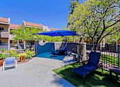 Thumbnail 31 of 36 - A patio with a blue umbrella and a blue chair.