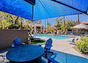 Thumbnail 33 of 36 - A blue table and chairs are set up under a blue canopy.