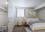 Thumbnail 2 of 20 - A bedroom with a bed, nightstand, and window.