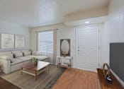 Thumbnail 3 of 20 - A living room with a white couch and a wooden coffee table.