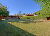 Thumbnail 9 of 16 - a house with a green lawn and a yard in front of it