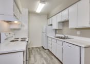 Thumbnail 14 of 17 - an empty kitchen with white cabinets and a sink and refrigerator