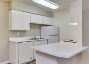 Thumbnail 7 of 17 - a kitchen with white cabinets and a sink and a refrigerator