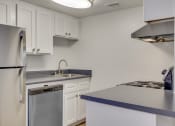 Thumbnail 16 of 17 - an empty kitchen with white cabinets and a stainless steel refrigerator