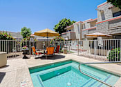 Thumbnail 59 of 94 - A pool surrounded by a fence and chairs.