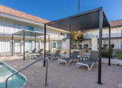 Thumbnail 24 of 25 - a patio with lounge chairs and a pool and a building