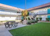 Thumbnail 21 of 25 - a courtyard with a picnic table and a lawn in front of a building