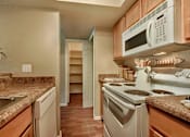 Thumbnail 11 of 15 - A kitchen with a stove, microwave, and oven. at Sycamore Square Apartments, Mesa, Arizona