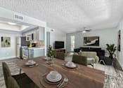 Thumbnail 5 of 18 - A dining table set with plates and cutlery is in the foreground of a modern kitchen and living room at Tela Verde Apartment Homes, Glendale, 85306