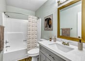 Thumbnail 8 of 18 - A bathroom with a white toilet, sink, and shower at Tela Verde Apartment Homes, Glendale, 85306