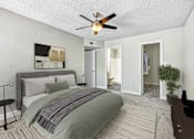 Thumbnail 6 of 18 - A bedroom with a bed, a ceiling fan, and a painting on the wall at Tela Verde Apartment Homes, Glendale, 85306