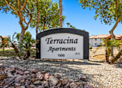 Thumbnail 12 of 17 - A sign for TerraCina Apartments is displayed in front of some trees.