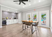 Thumbnail 14 of 17 - A kitchen with a dining table and chairs in the middle of the room.