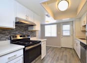 Thumbnail 1 of 9 - a kitchen with white cabinets and a black stove top oven