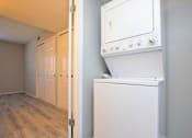 Thumbnail 5 of 9 - a white washer and dryer in a room with a wooden floor