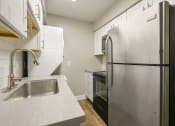Thumbnail 1 of 10 - a kitchen with a stainless steel refrigerator and sink