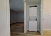 Thumbnail 11 of 16 - A white fridge in a room with wooden floors and white walls.