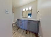 Thumbnail 12 of 16 - A bathroom with a vanity and a toilet.