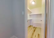 Thumbnail 15 of 16 - A white doorway opens to a small room with a bed and a light on the ceiling.
