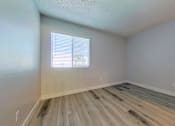 Thumbnail 8 of 16 - A room with wooden flooring and a window with blinds.