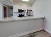 Thumbnail 3 of 16 - A kitchen with white cabinets and appliances.