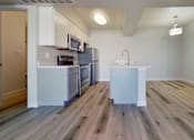 Thumbnail 2 of 16 - A kitchen with a white fridge and wooden floors.