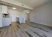 Thumbnail 4 of 16 - A room with a wooden floor and white walls.