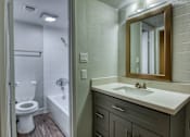 Thumbnail 4 of 14 - A bathroom with a toilet, sink, and mirror. at The Link Apartments, Mesa, AZ, 85201