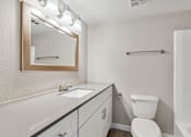 Thumbnail 5 of 12 - A bathroom with a white toilet, sink, and mirror at Tides on East Cactus Apartments, Phoenix, AZ