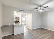 Thumbnail 3 of 12 - A room with a ceiling fan and a kitchenette in the background at Tides on East Cactus Apartments, Phoenix, AZ