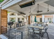 Thumbnail 10 of 12 - A patio with a table and chairs is covered by a roof at Tides on East Cactus Apartments, Phoenix, AZ, 85032