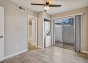 Thumbnail 7 of 12 - A room with a ceiling fan and a window with a view of the outside at Tides on East Cactus Apartments, Phoenix