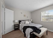 Thumbnail 8 of 28 - A bedroom with a bed, nightstand, and window  at Tides on McDowell, Phoenix, 85035